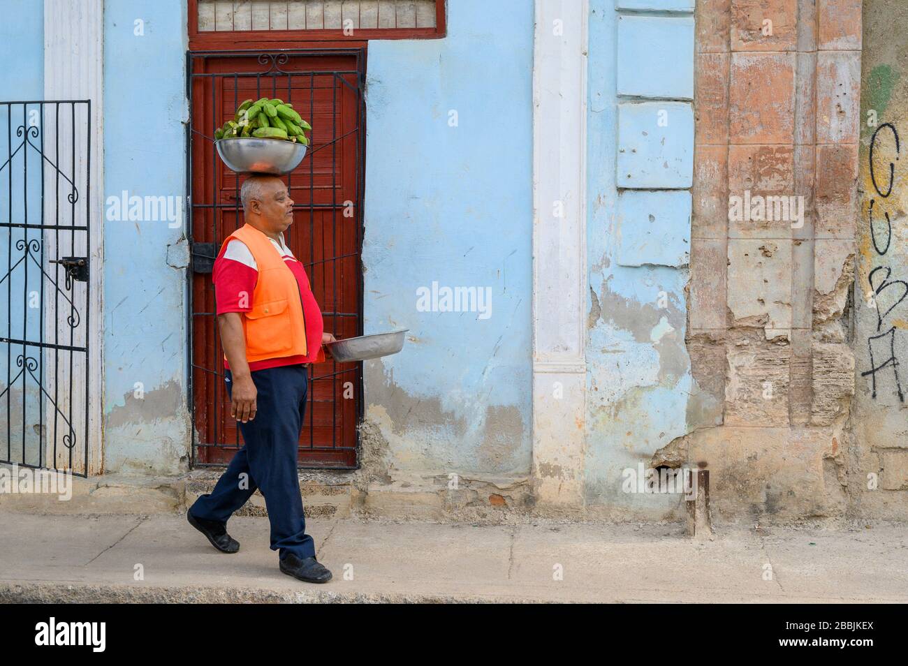 Man balancing bowl of plantain on head, Havana, Cuba Stock Photo
