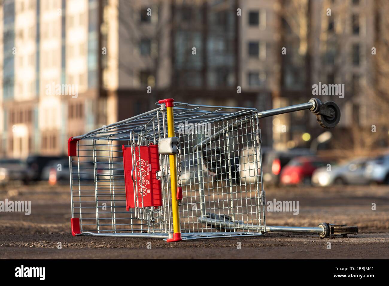 Inverted empty shopping cart on the street. Coronavirus pandemic effect - quarantine and isolation of the population in cities. Crisis, panic buying f Stock Photo