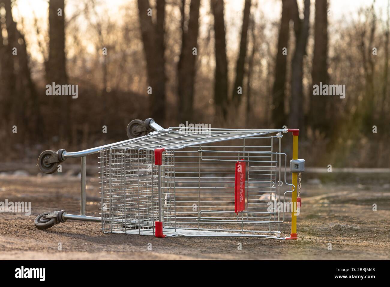 Inverted empty shopping cart on the street. Coronavirus pandemic effect - quarantine and isolation of the population in cities. Crisis, panic buying f Stock Photo