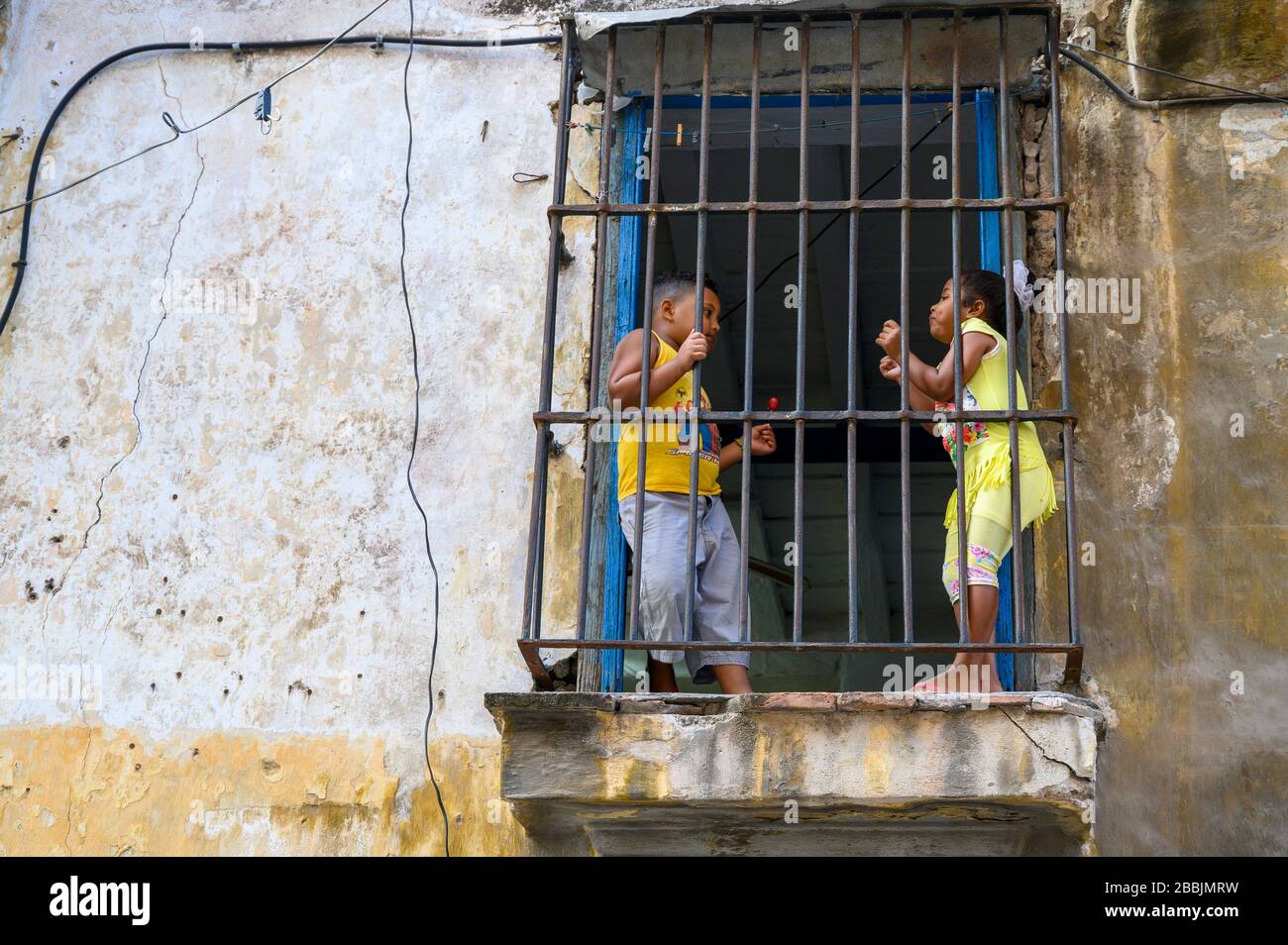 Children behind window bars, Havana, Cuba Stock Photo