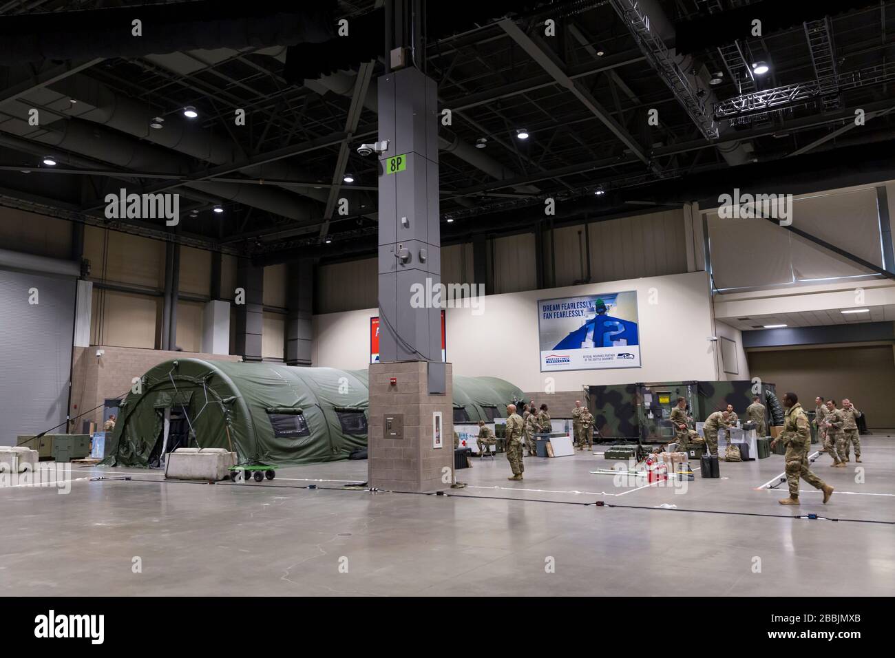 Soldiers assemble the pre-op room (left) at the field hospital in CenturyLink Field Event Center in Seattle, Washington on March 31, 2020. Soldiers from the 627th Army Hospital at Fort Carson, Colorado are deploying a field hospital for non-COVID-19 cases that will house 150 beds when completed. Stock Photo