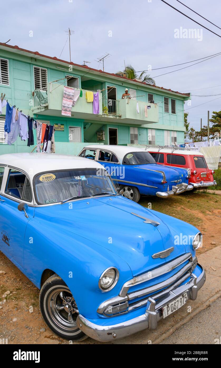 Vintage cars and apartment building, Vinales, Pinar del Rio Province, Cuba Stock Photo