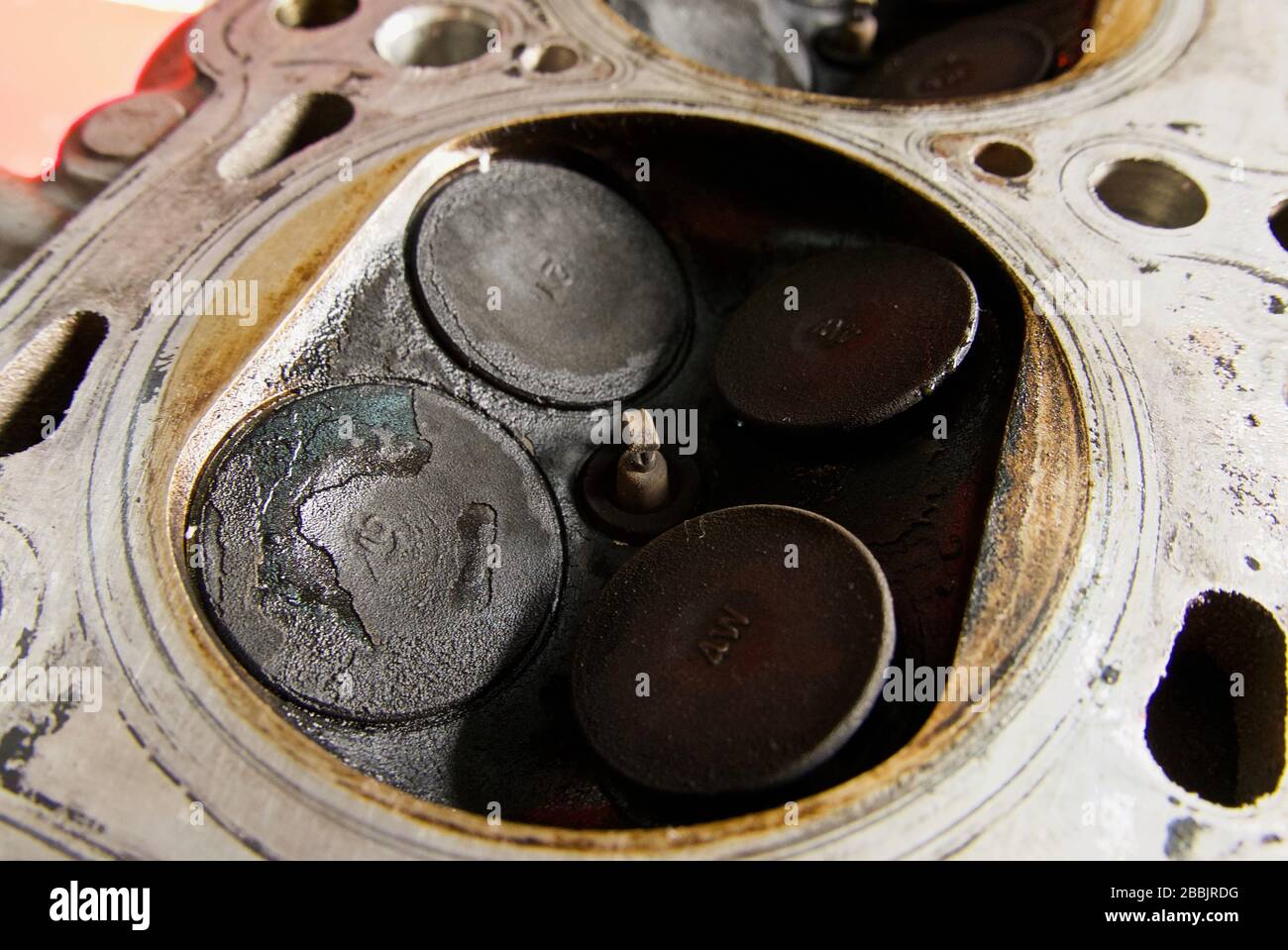 Burnt valves in a car cylinder head, illustrating poor maintenance