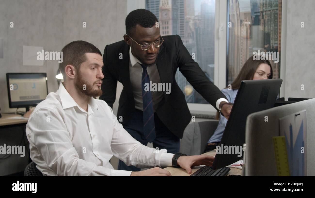 Coworkers discuss a problem in the office, solve it Stock Photo