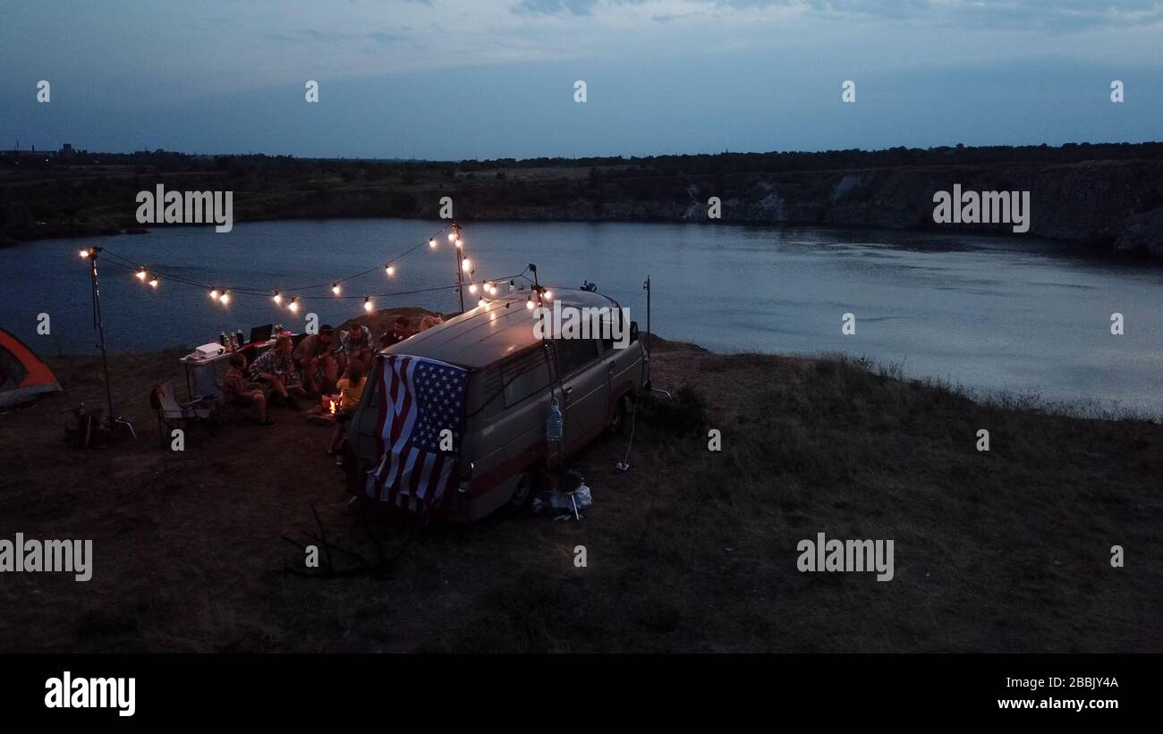 Friends Having Rest in Campsite Having Drinks Stock Photo