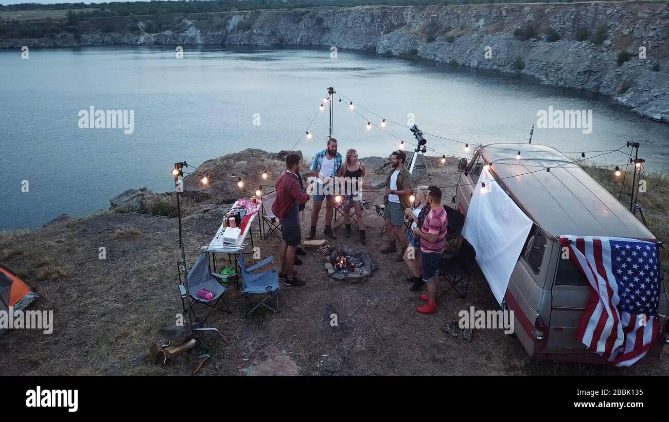 Friends Having Rest in Campsite Having Drinks Stock Photo