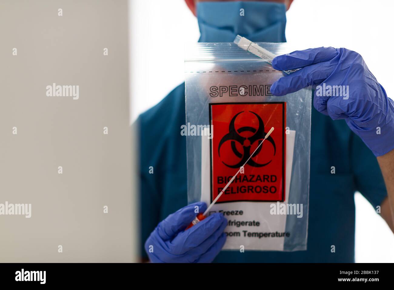 medical laboratory scientist holding a plastic bag containing test tube with throat swab viral specimen collection equipment, Coronavirus Stock Photo