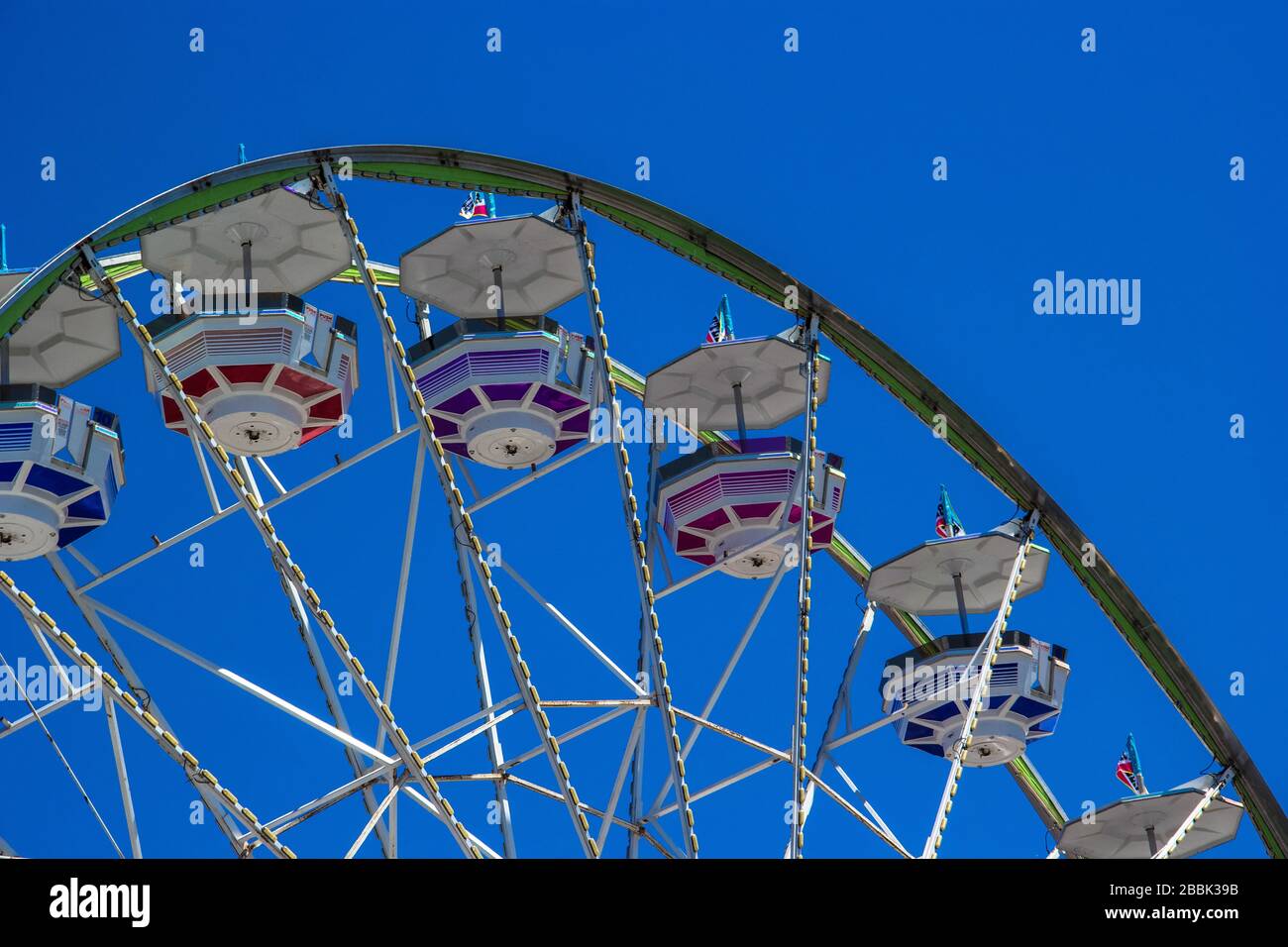 A ferris wheel ride against a blue sky Stock Photo