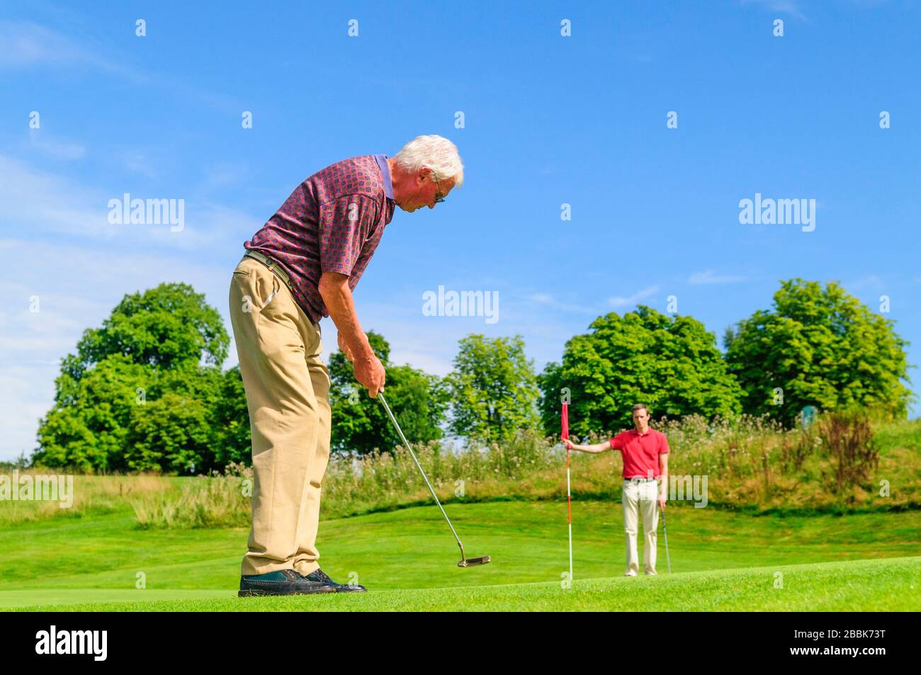 Young and old man playing golf Stock Photo Alamy