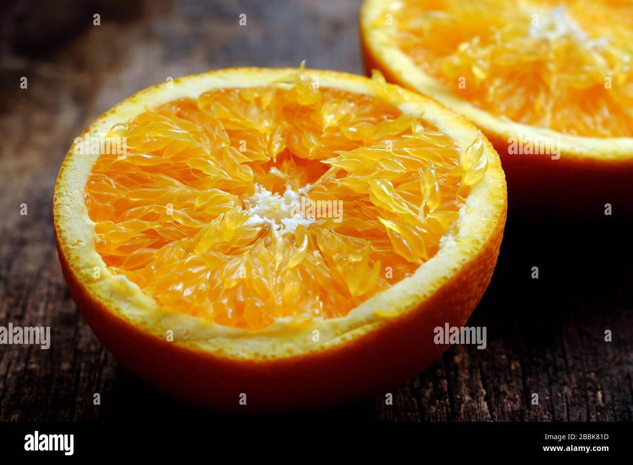 Close up from high view of yellow orange fruit cut two in half, freshness raw fruit of citrus, rich vitamin c, good for health on wooden background Stock Photo