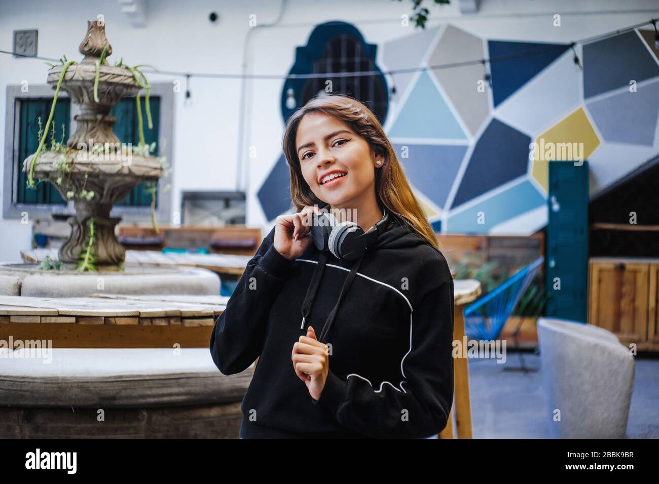Happy latin teenager girl listening music in headphones in Mexico city Stock Photo