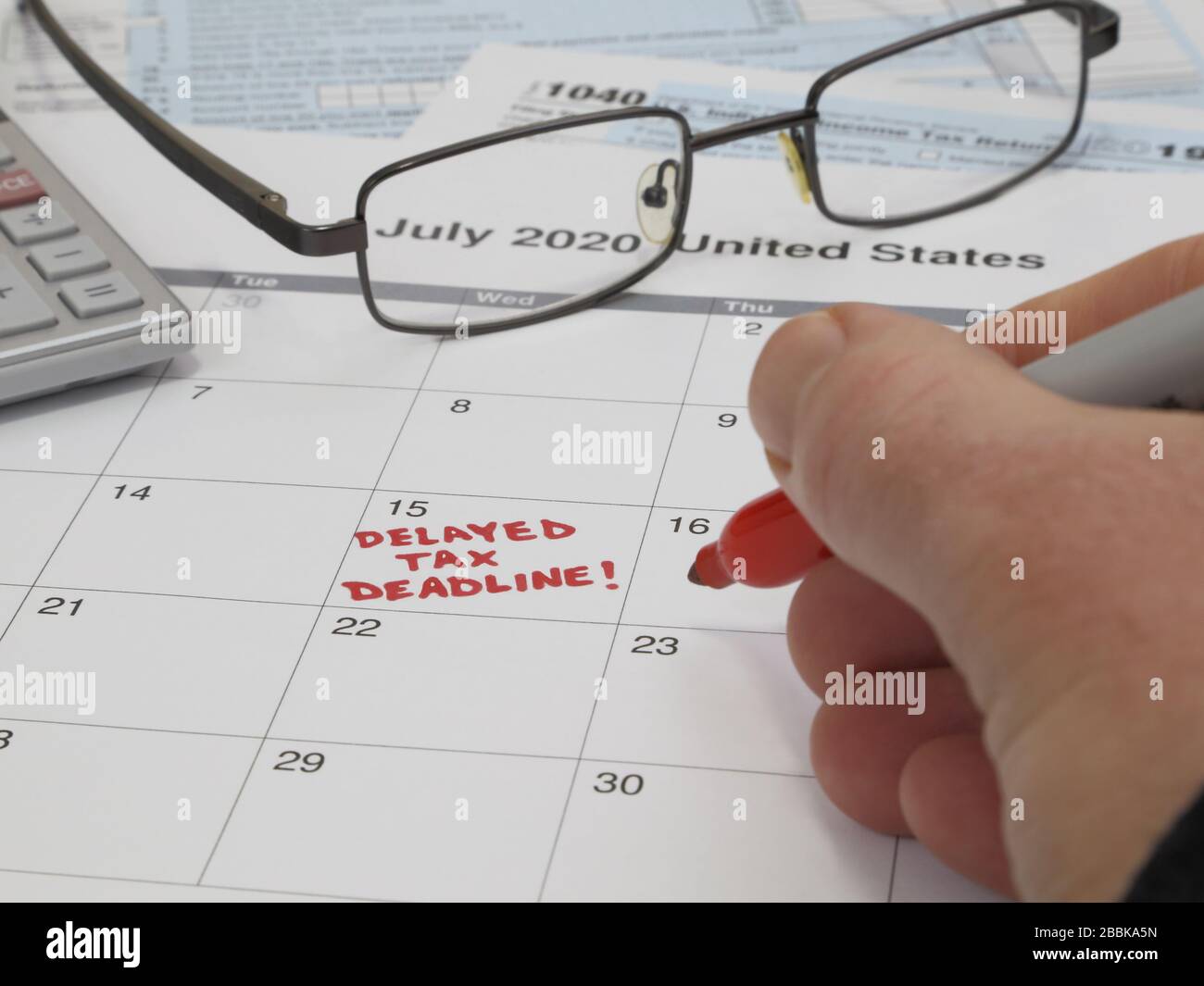 A calendar notes the USA Internal Revenue Service IRS income tax filing deadline has been moved from April 15 to July 15, 2020. Stock Photo