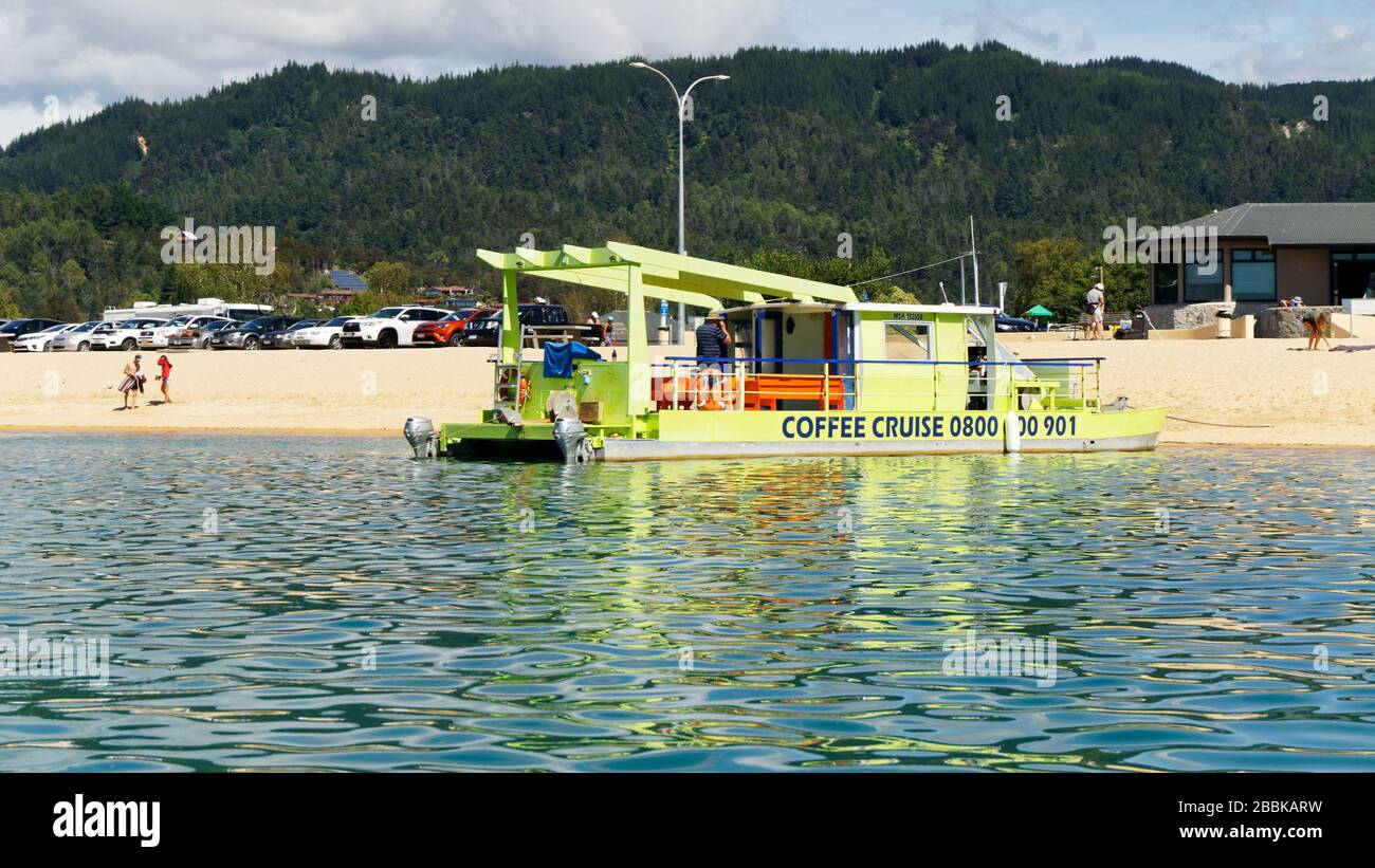 Kaiteriteri, Tasman/New Zealand - March 3, 2017: Coffee and cruise tour operator's green catamaran at Kaiteriteri Beach, Tasman region, New Zealand. Stock Photo