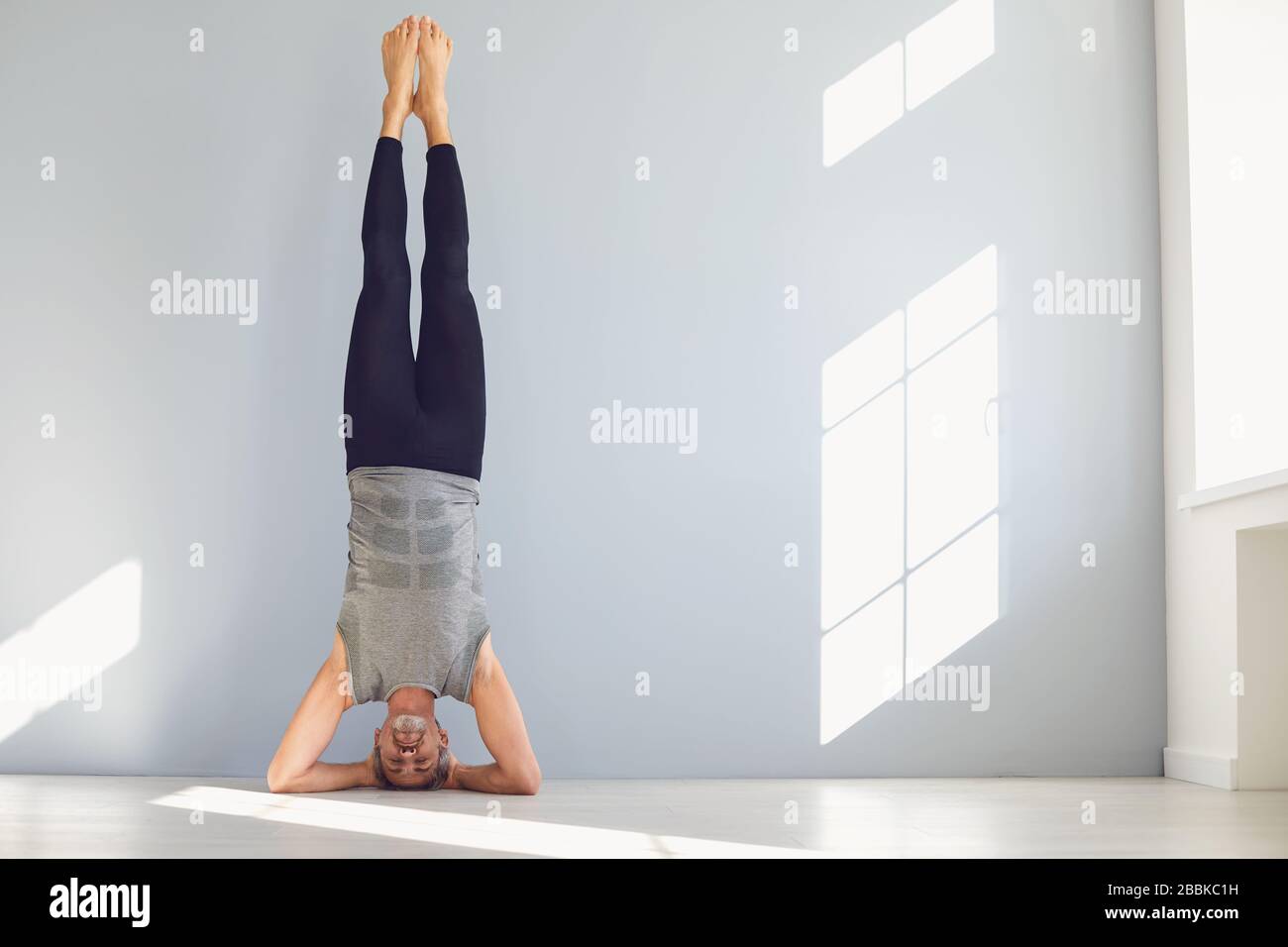 Sportive man doing yoga exercise in studio Stock Photo