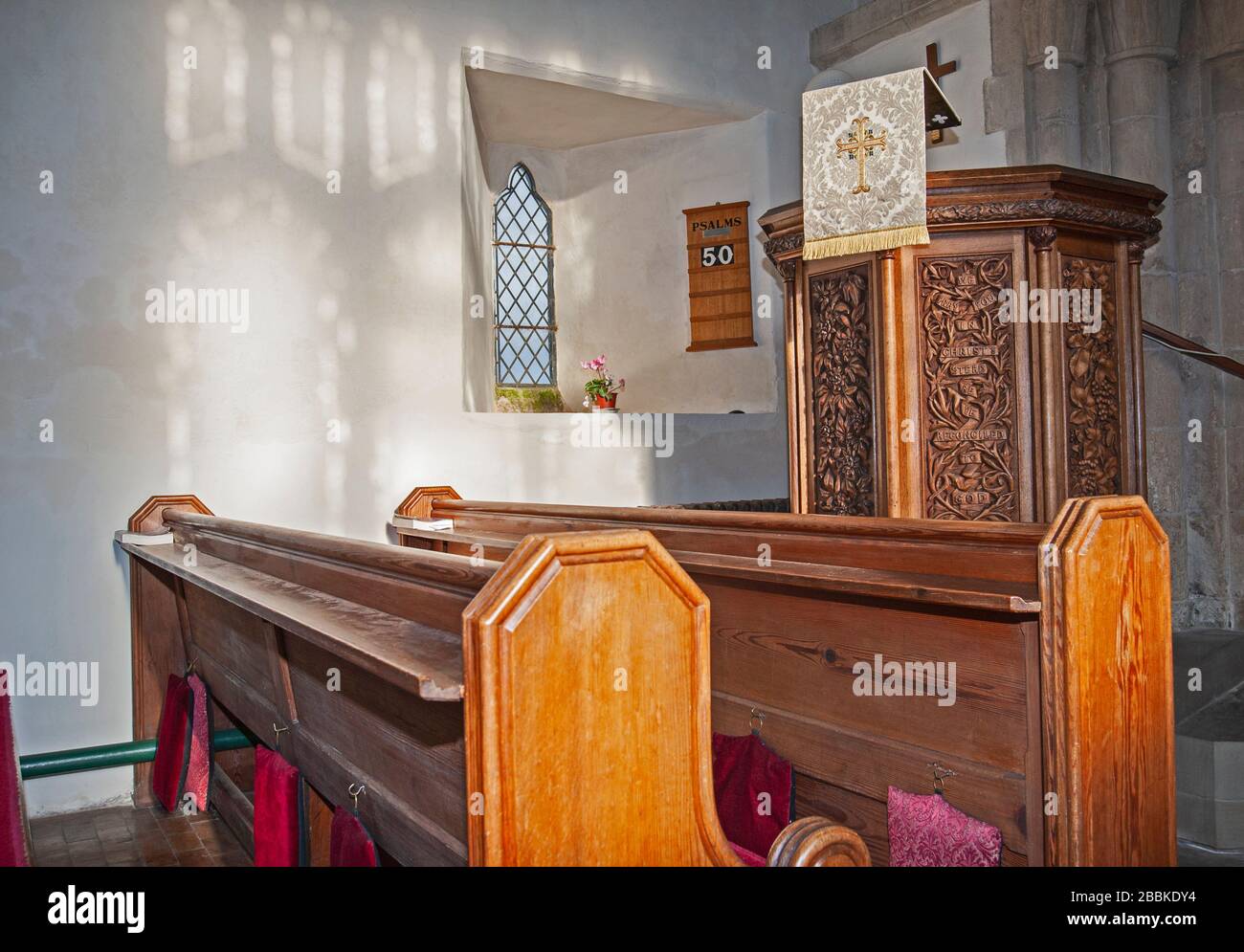 Interior of small medieval village church with pew seating and altar Stock Photo