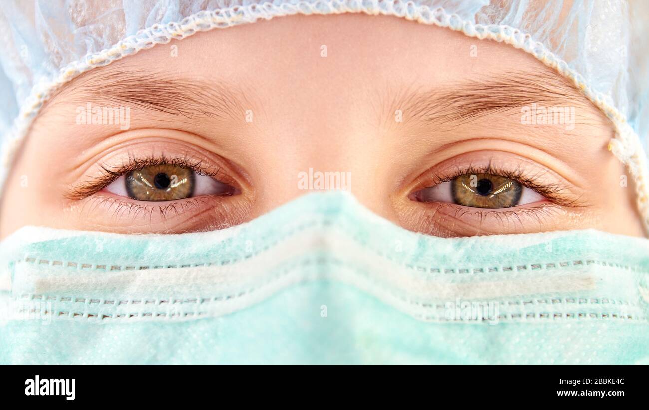 The child in a medical mask and safety cap. Coronavirus protection. Closeup Stock Photo