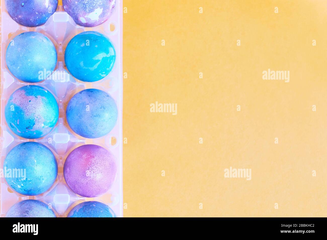 Painted Easter eggs with space intergalactic pattern in stand on yellow background Stock Photo