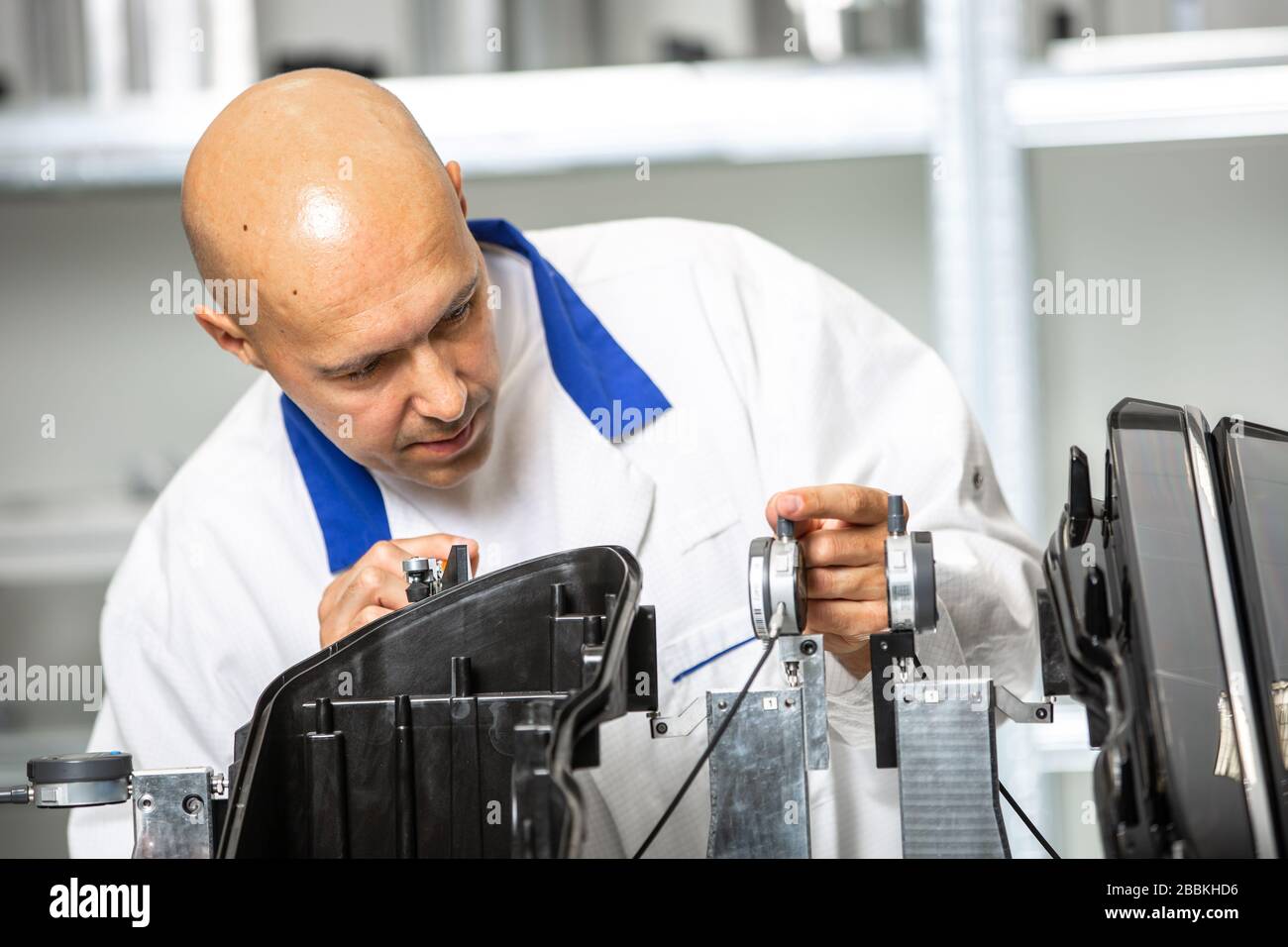 Quality engineer measuring plastic components by digital meter on the