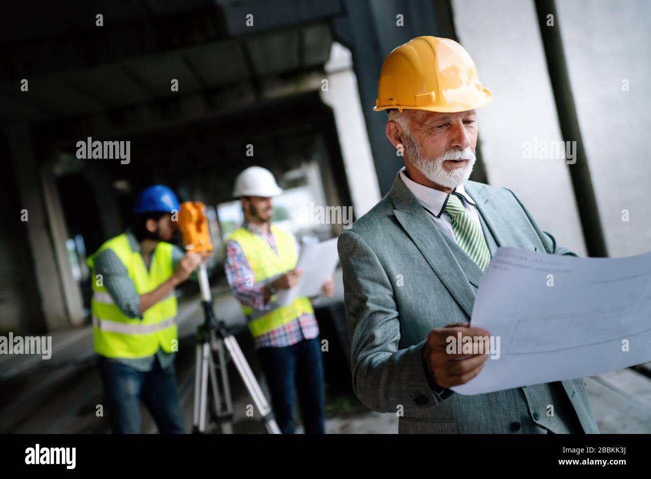 Two satisfied engineers talking at building site with construction structure in background Stock Photo