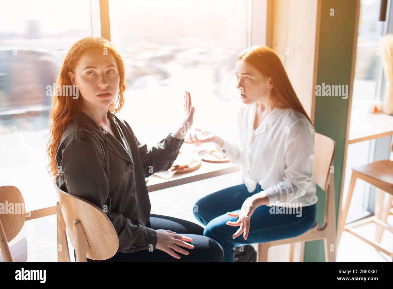 Female model stops with a hand a colleague and turns away. Young woman upset and disagree. Stock Photo