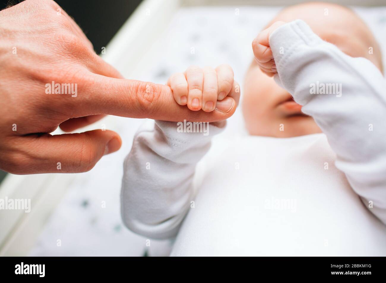 Closeup feet of a newborn baby. Little infant is lying on the kids
