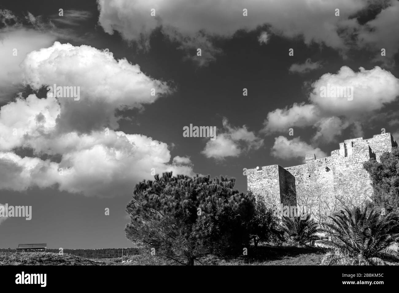 The Rocca Aldobrandesca of Talamone, Grosseto, Tuscany, Italy, against a dramatic and picturesque sky, in black and white Stock Photo