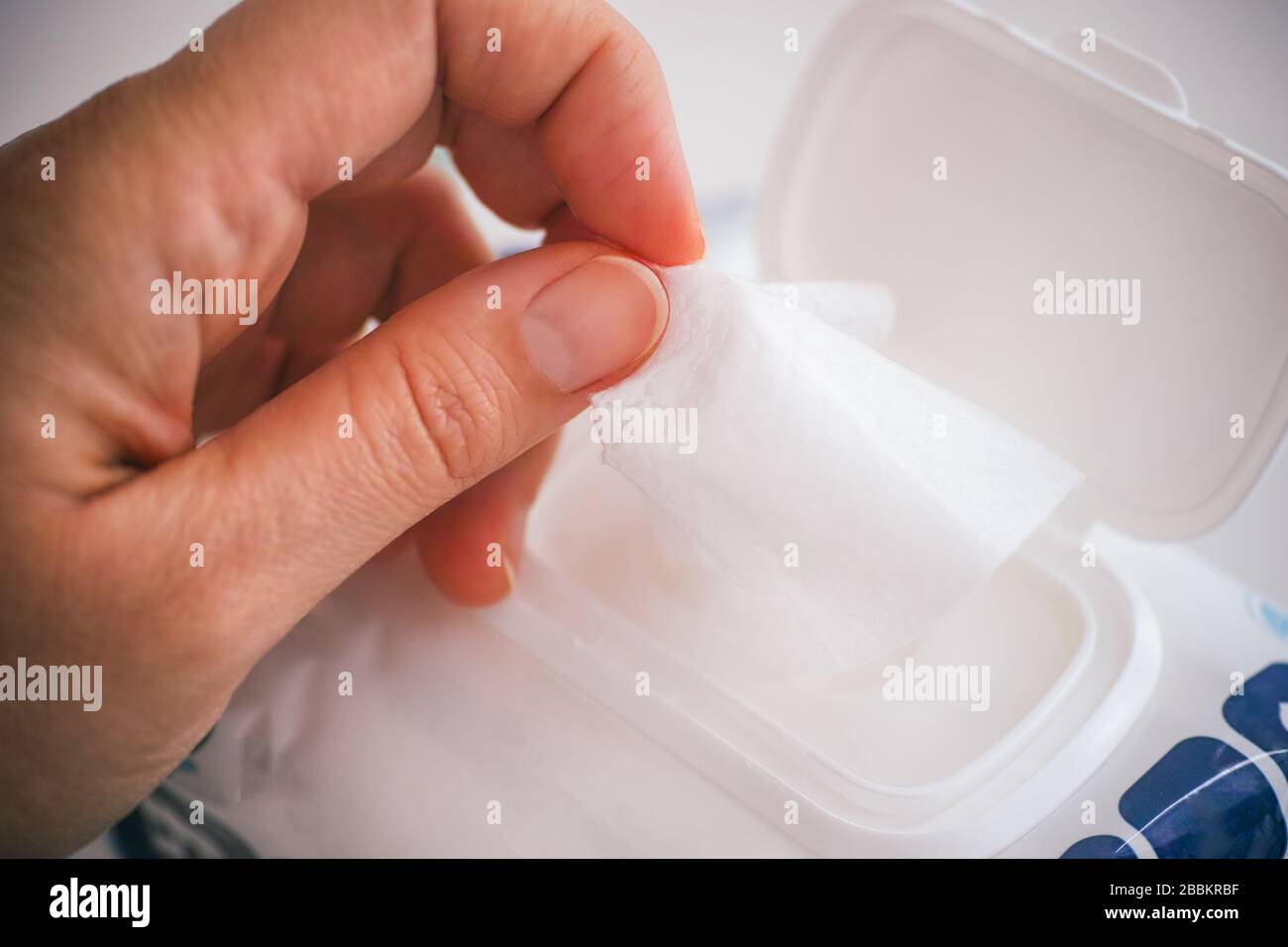 Woman hand taking wet wipe from package. Stock Photo