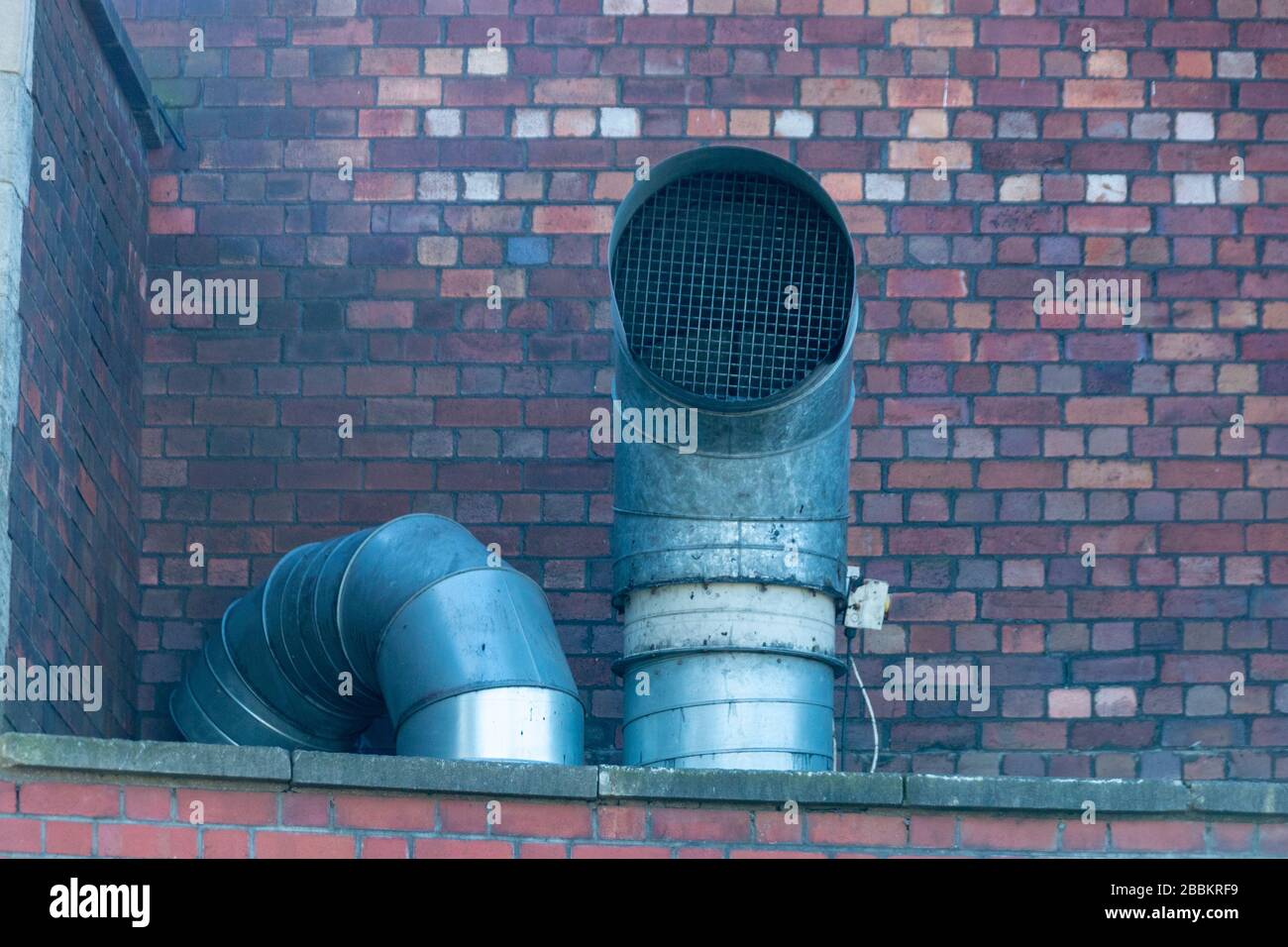 a close up view steam coming out the top of two large metal air ventaltion ducts Stock Photo