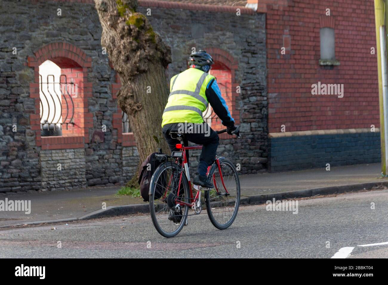 Bristol-March 2020-England- A close up view of a man riding his bike to the shop or to work on a cold summers morning Stock Photo
