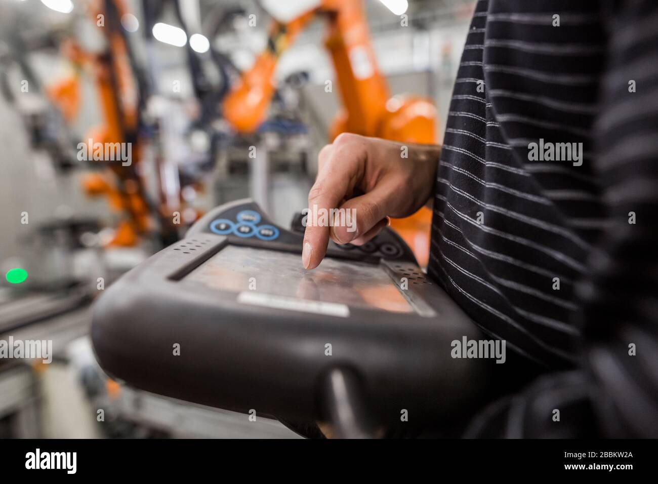 Technician man programming robot in automotive industrial, professional ...