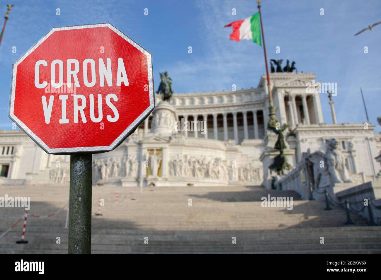 Corona virus sign with Altar of the Fatherland in Rome, Italy. Coronavirus pandemic outbreak concept in north Italy. Stock Photo