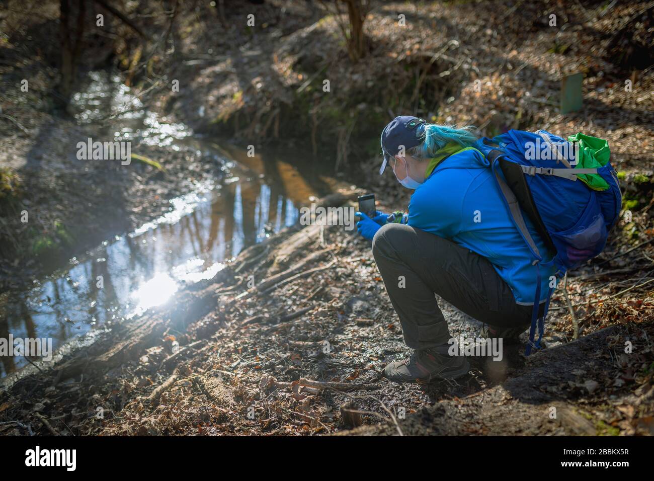 woman shooting a river in forest by phone Stock Photo