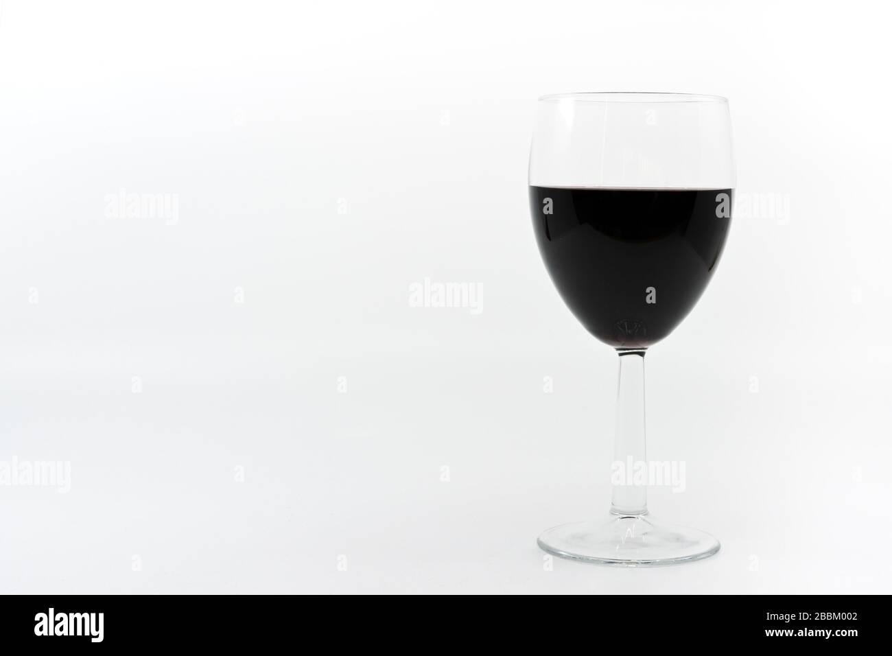 Glass of red wine on a plain white background with space for copy Stock Photo