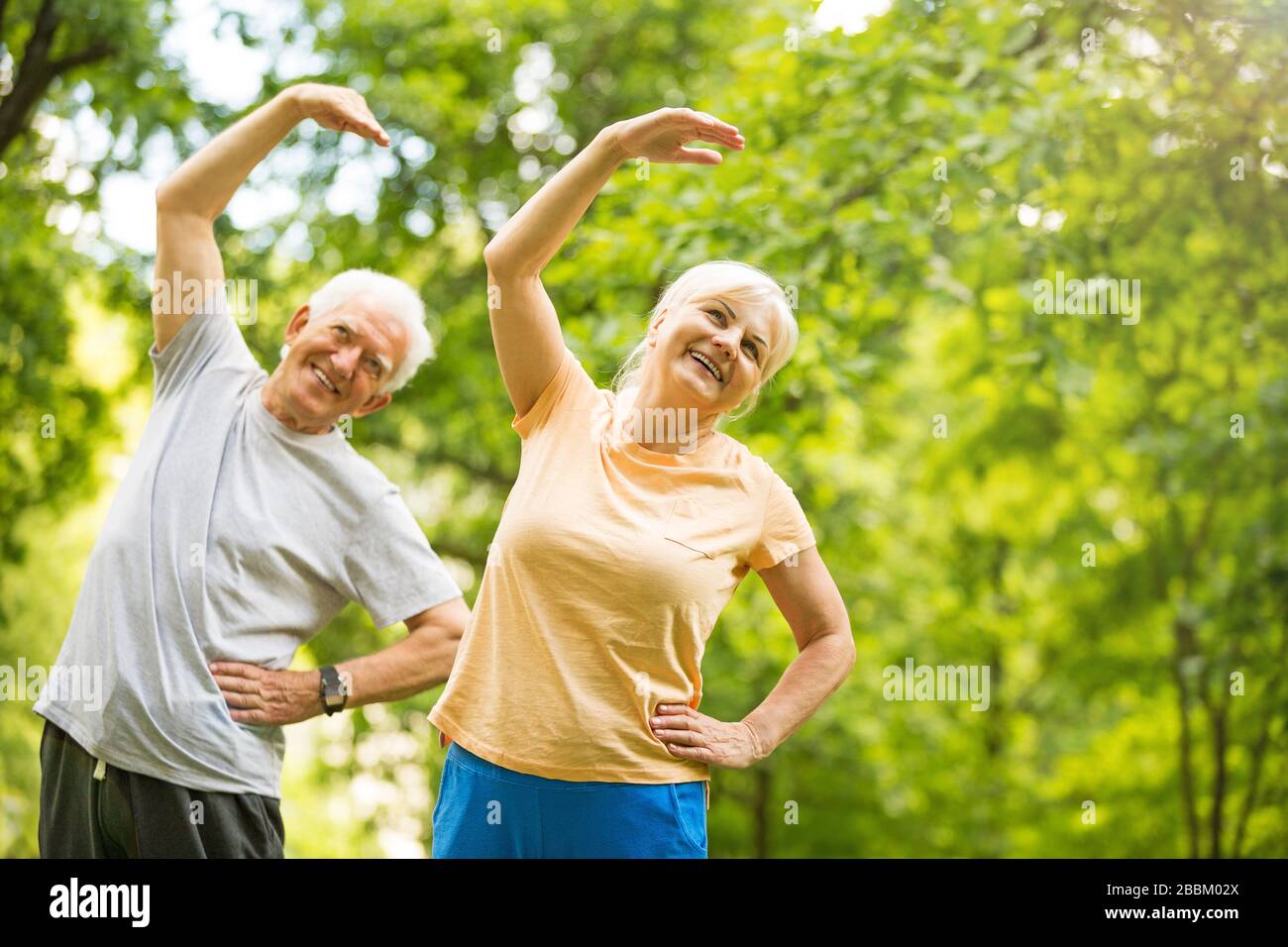 Senior Couple Exercising In Park Stock Photo