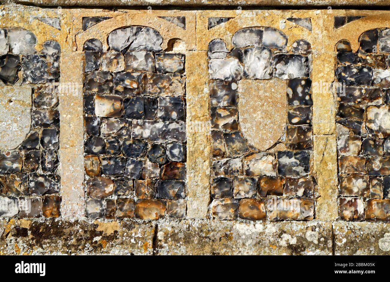 Detail of base course of flushwork in the 15th century south porch of the parish Church of St Peter at Ringland, Norfolk, England, UK Europe. Stock Photo