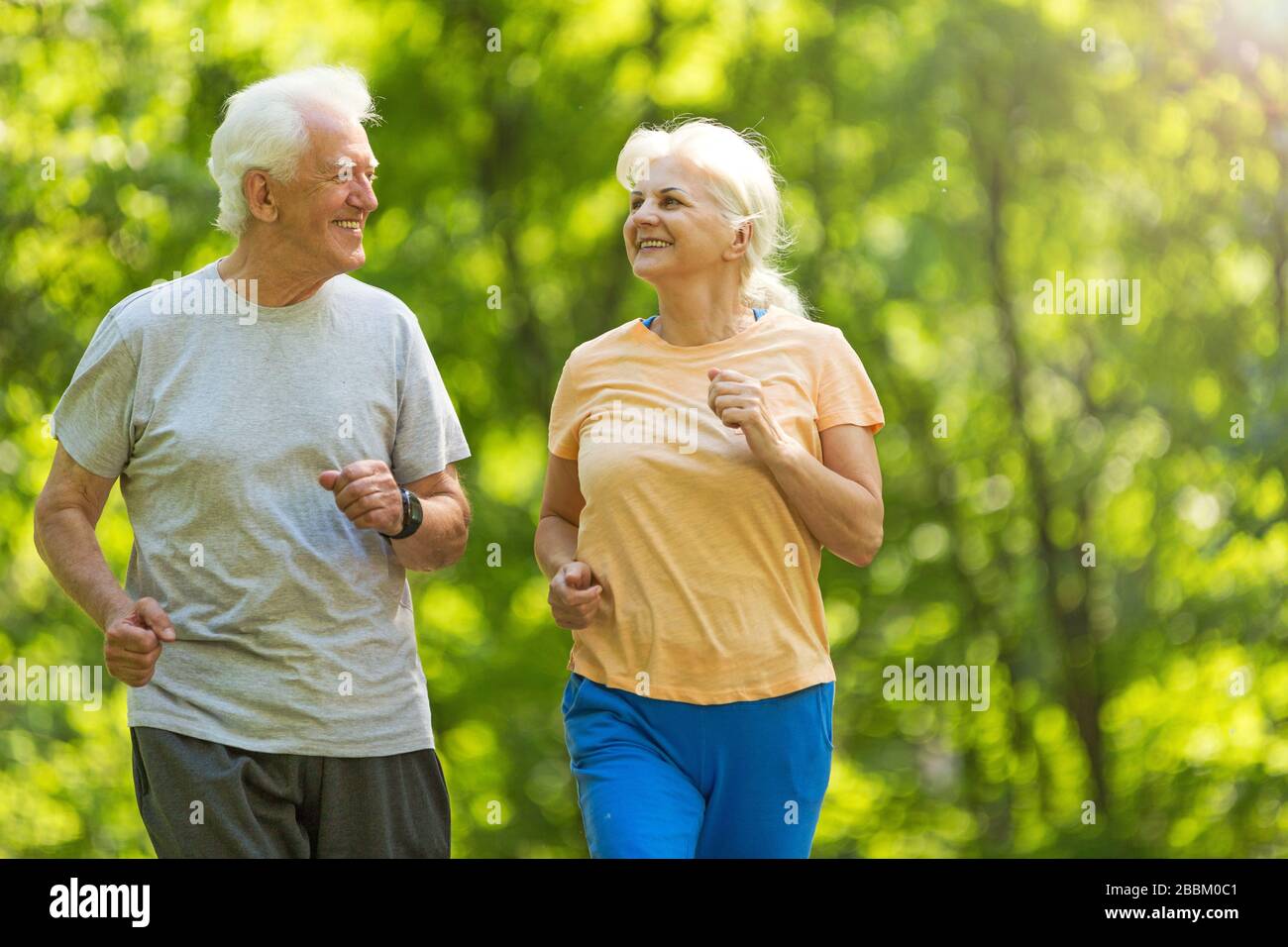Senior Couple Exercising In Park Stock Photo