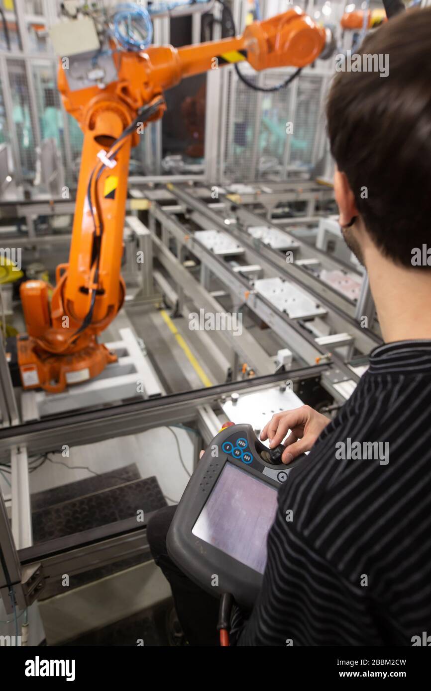 Man programming robot in automotive industrial, professional programmer, industry concept Stock Photo