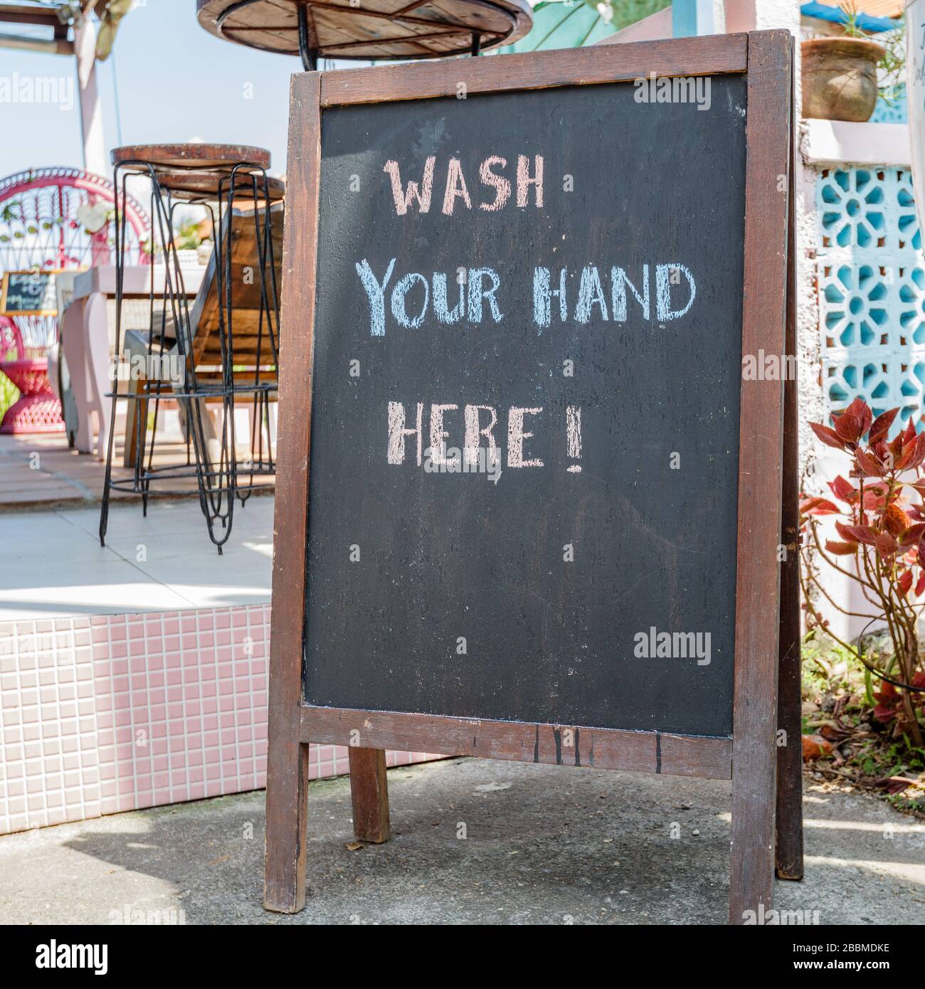 Cafe sign 'wash your hands here' during quarantine for COVID-19. Canggu, Bali popular tourist area. Indonesia. Square image. Stock Photo