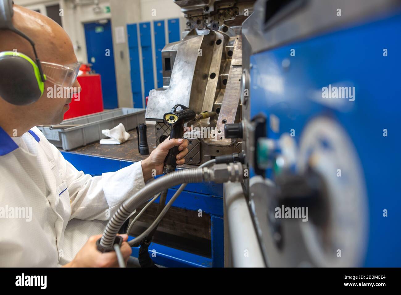 Engineer doing maintenance on a injection mold for plastic components, industrial and automotive concept Stock Photo