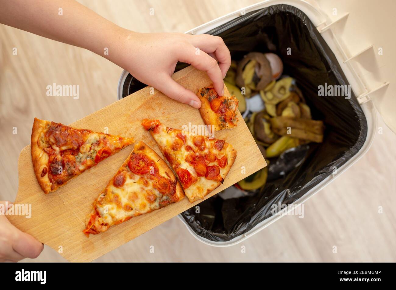 https://c8.alamy.com/comp/2BBMGMP/woman-hands-throwing-food-into-the-trash-bin-waste-of-food-food-concept-2BBMGMP.jpg