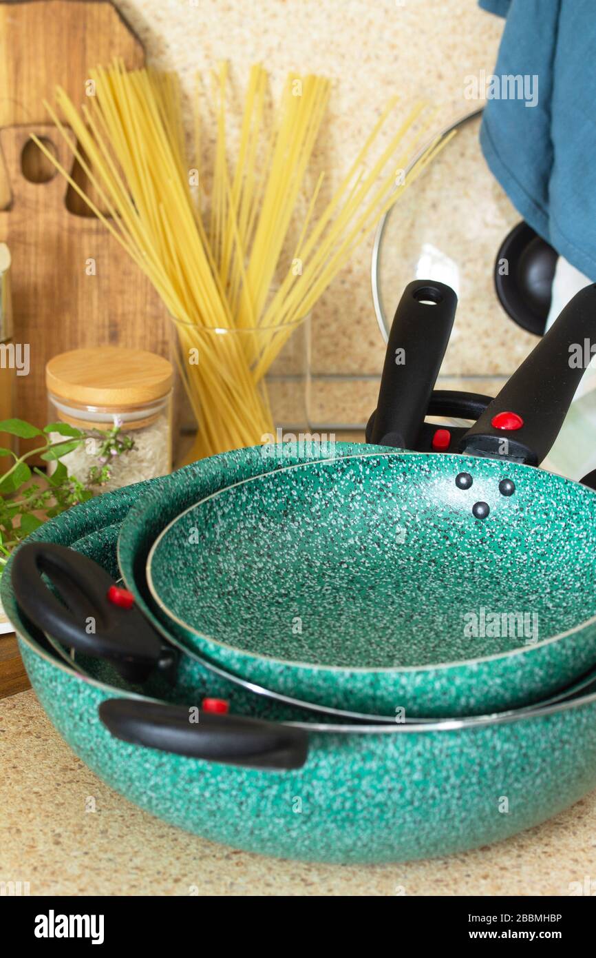 Set of empty ceramic coated dishes on a stone kitchen worktop surrounded. Kitchen table