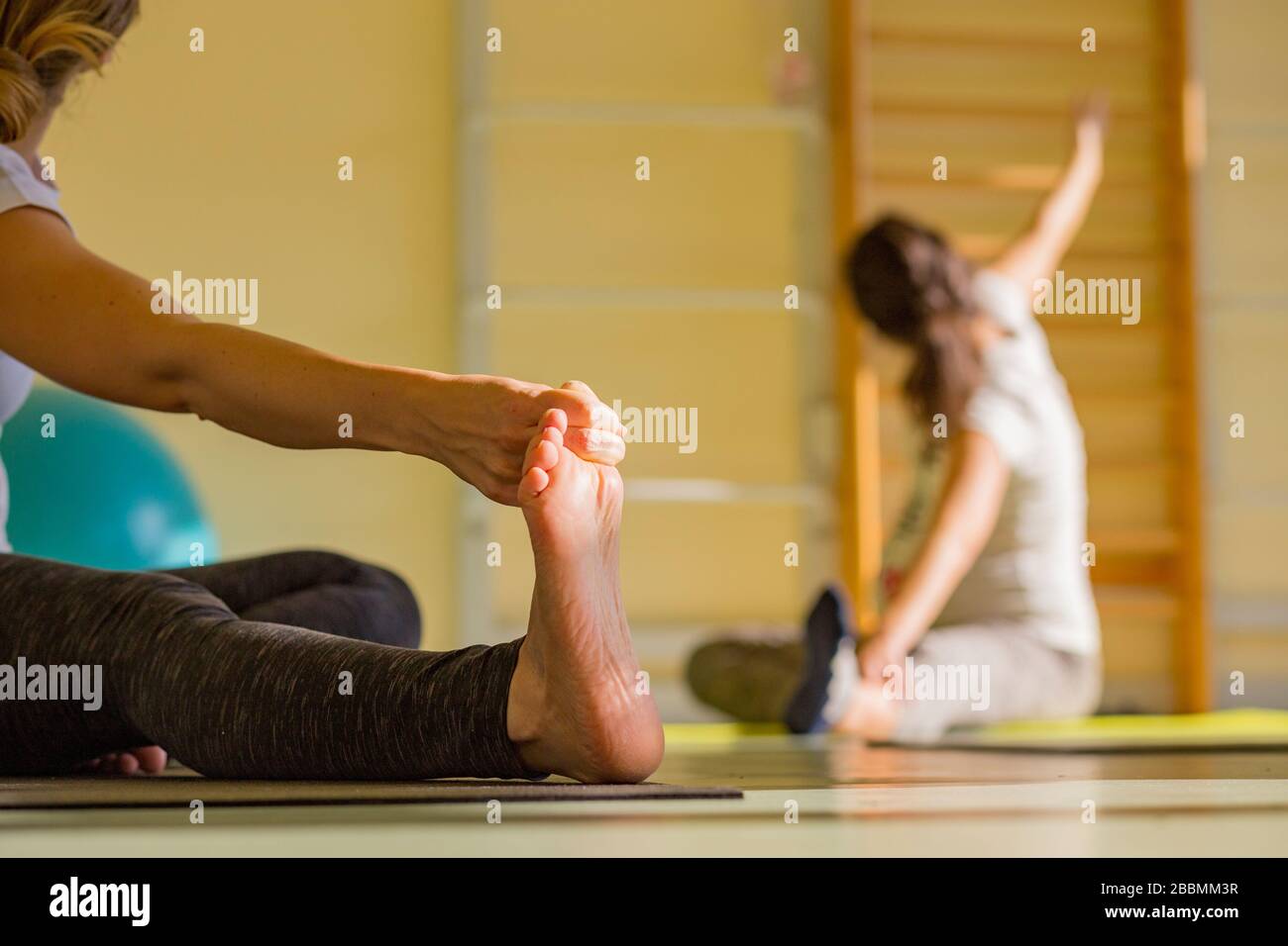 Stretching at a prenatal yoga practice session Stock Photo