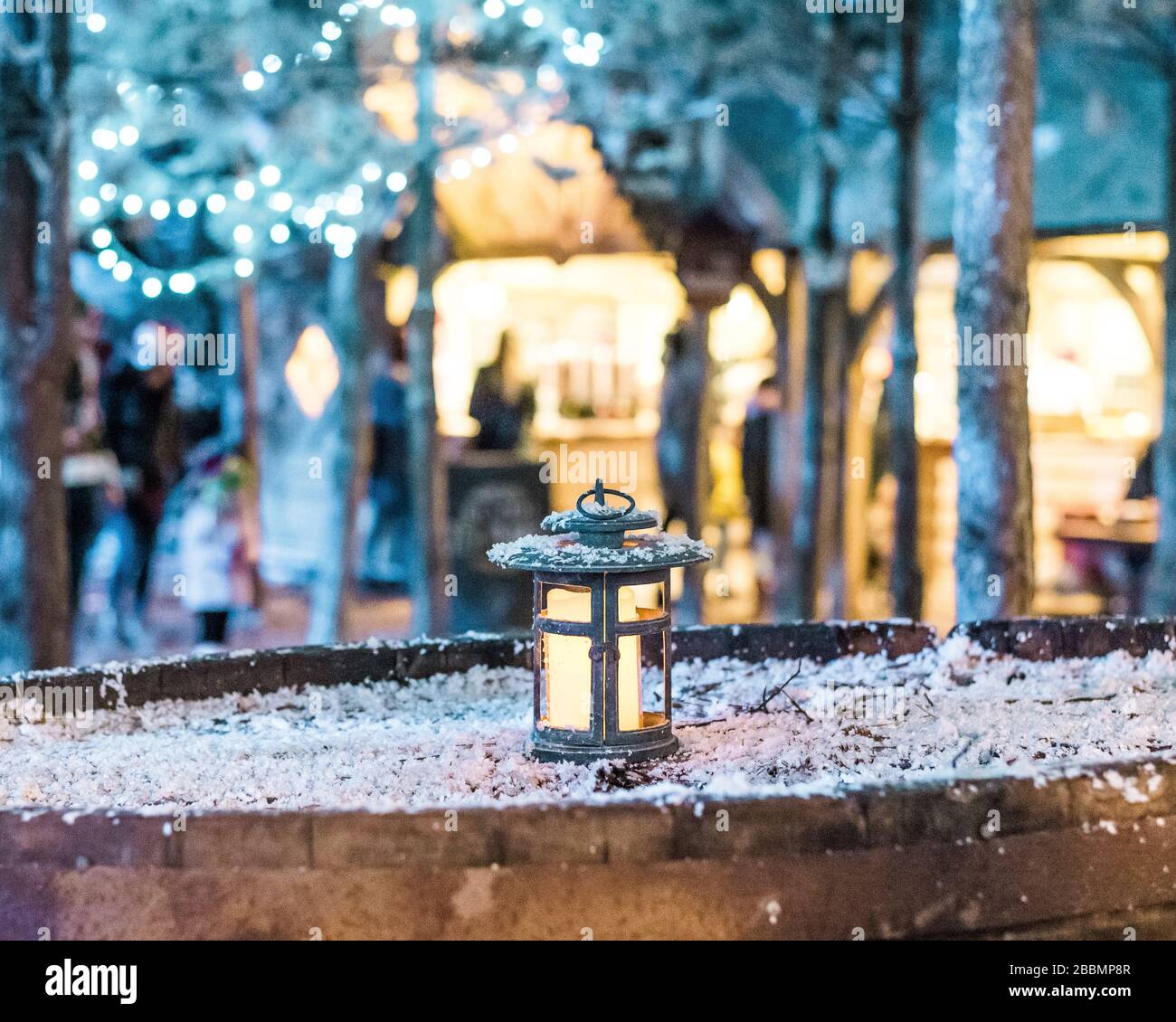 A glowing lantern on a snowy beer barrel at Christmas in England Stock Photo
