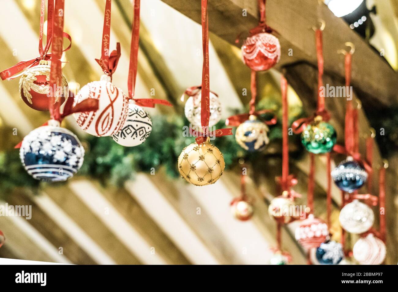 Multi coloured handmade Christmas baubles hanging in a stall in England Stock Photo