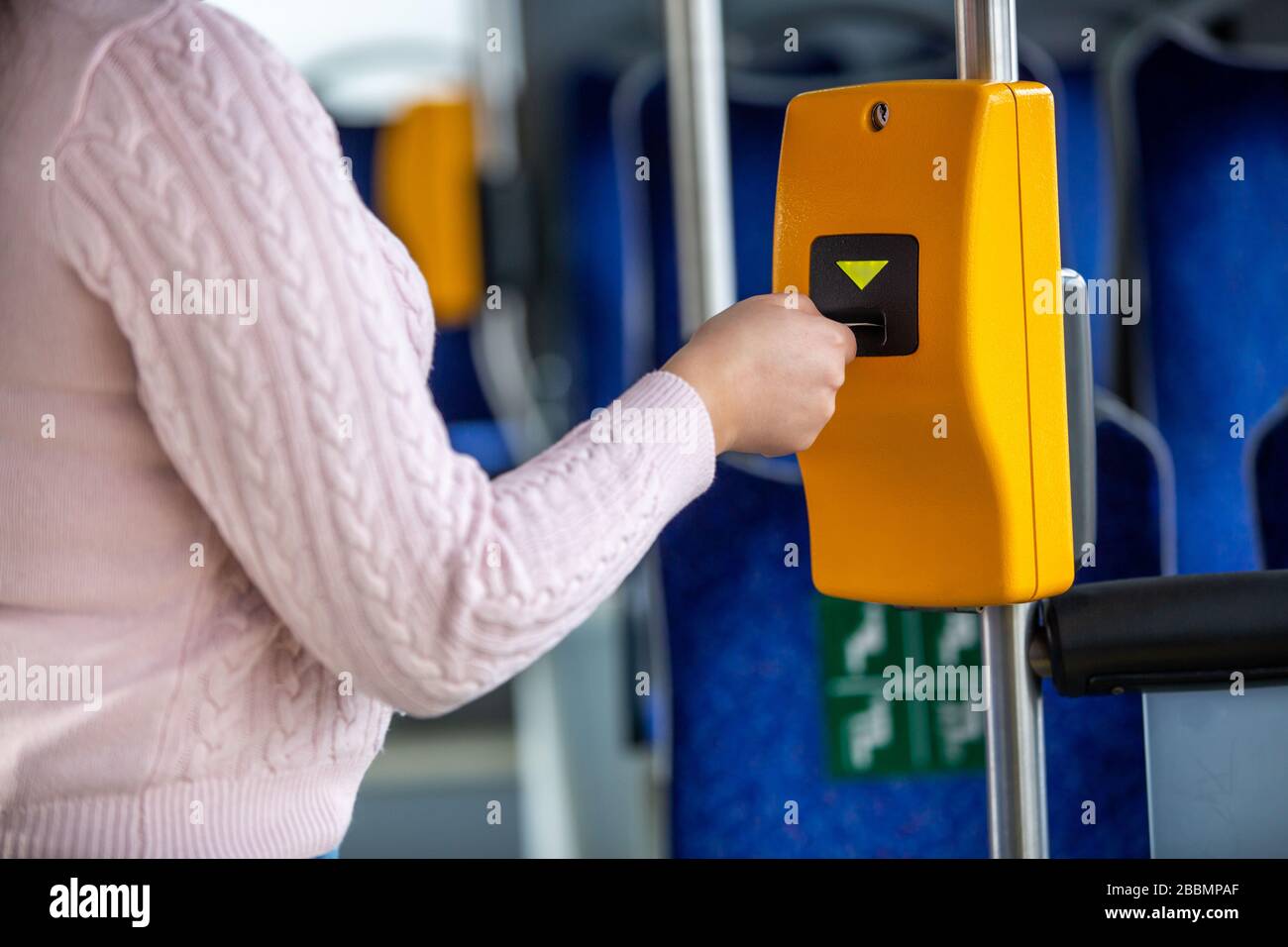 Young woman validates ticket in a public transport during ...