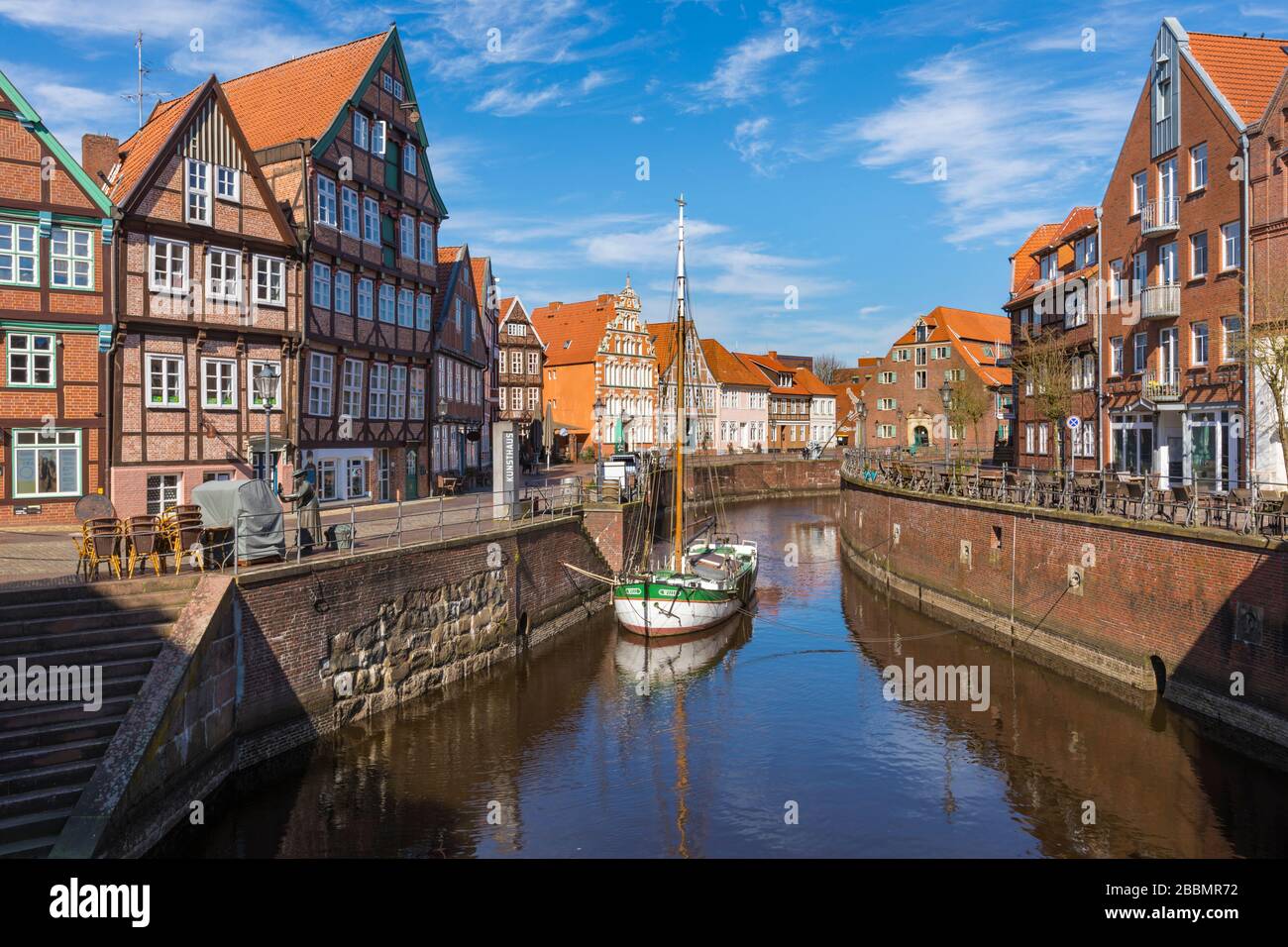 Old harbor with half-timbered houses and historic flat bottom boat at the old town of Stade, Lower Saxony, Germany Stock Photo