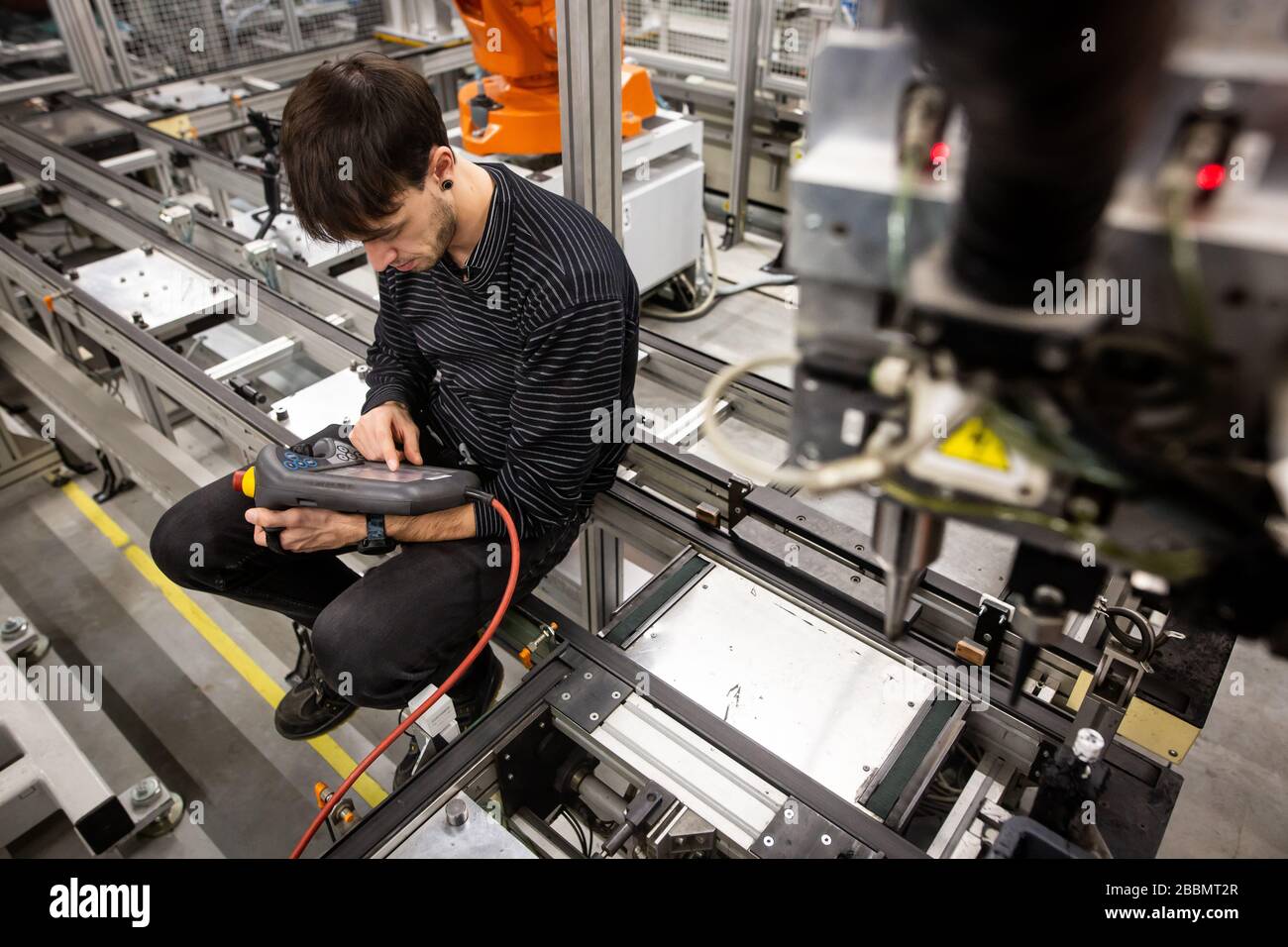 Man programming robot in automotive industrial, professional programmer ...