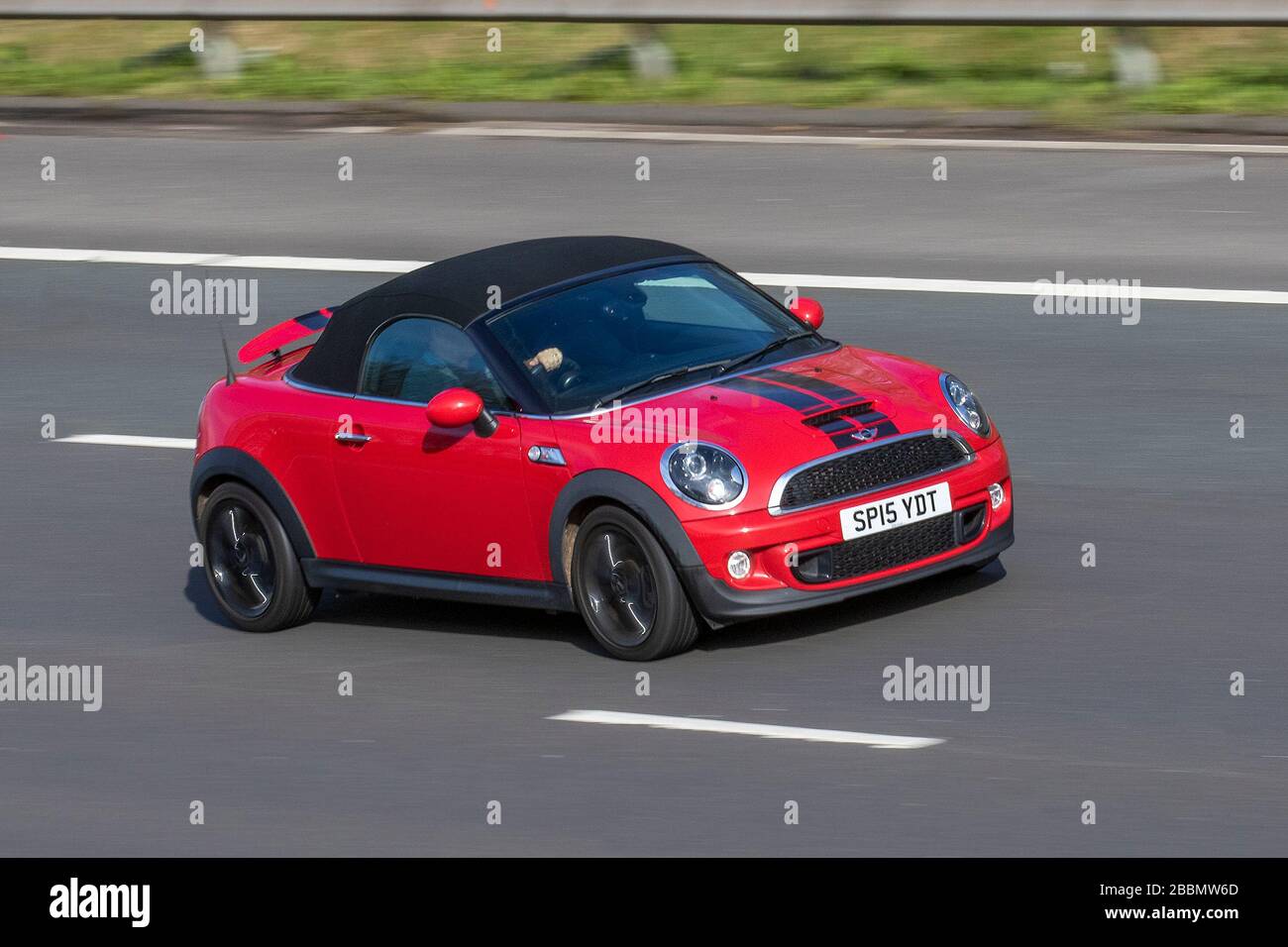 2015 red Mini Mini Roadster Cooper S; Vehicular traffic moving vehicles, vehicle driving, roads, motors, motoring on the M6 motorway highway Stock Photo