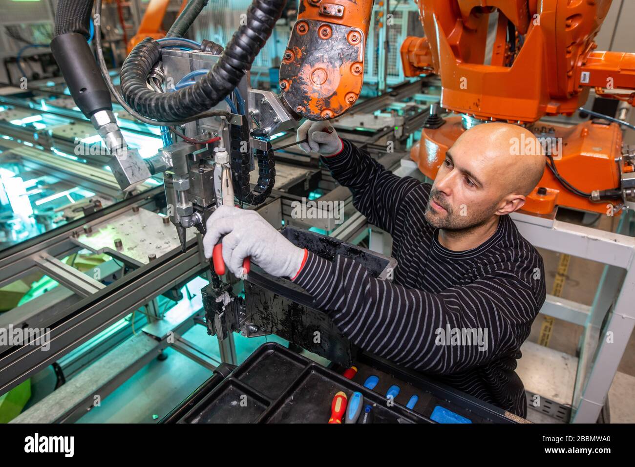 Engineer doing maintenance on a automatic robot arms in automotive industrial, smart factory Stock Photo