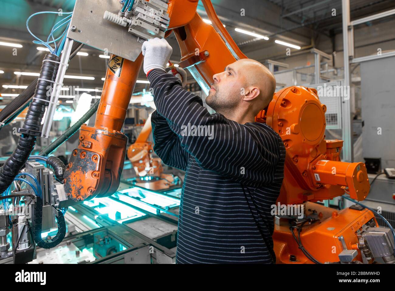Engineer doing maintenance on a automatic robot arms in automotive industrial, smart factory Stock Photo